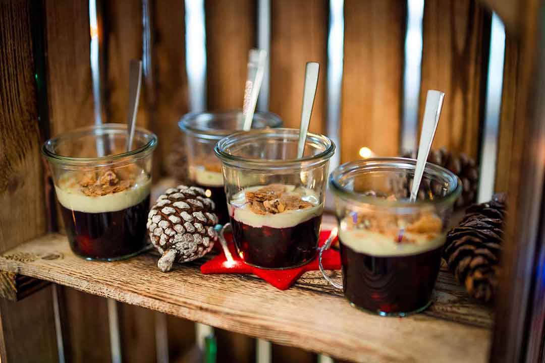 Auf dem Bild sind Desserts in Gläschen zu sehen, es verdeutlicht die Vorteile eines Caterings zu Weihnachten, das sich um das Weihnachtsbuffet für die Firmenweihnachtsfeier kümmert.
